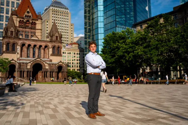 Owen Connery in a Boston courtyard as city skyrises stand in the background.