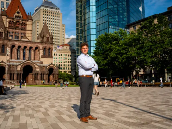 Owen Connery in a Boston courtyard as city skyrises stand in the background.