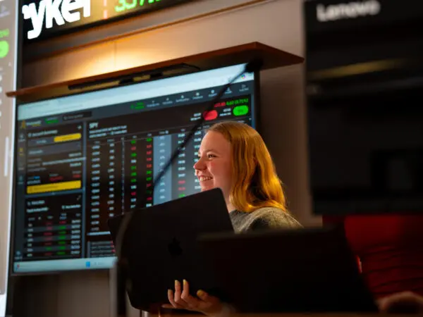 Photo of smiling student in the Bloomberg Finance Lab.