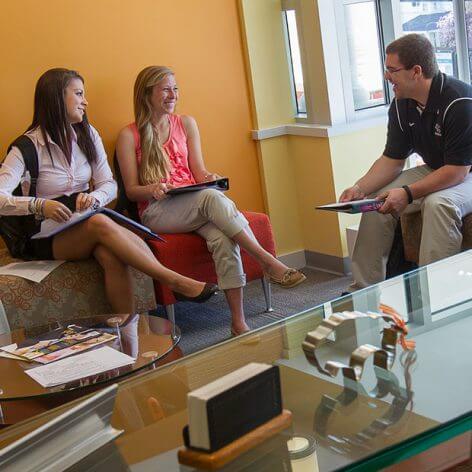 two students meeting with staff