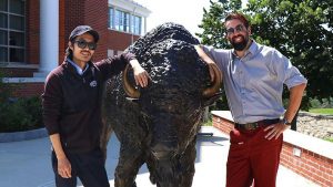 Charles and Dave, Nichols College's eSports Coaches standing next to Nichols College's bison statue, Thunder.