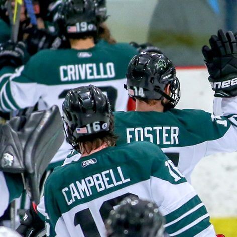 Nichols College Men's Hockey Captain high fiving his teammates