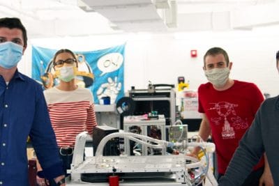 Nick Anderson and three other persons standing next to a ventilator