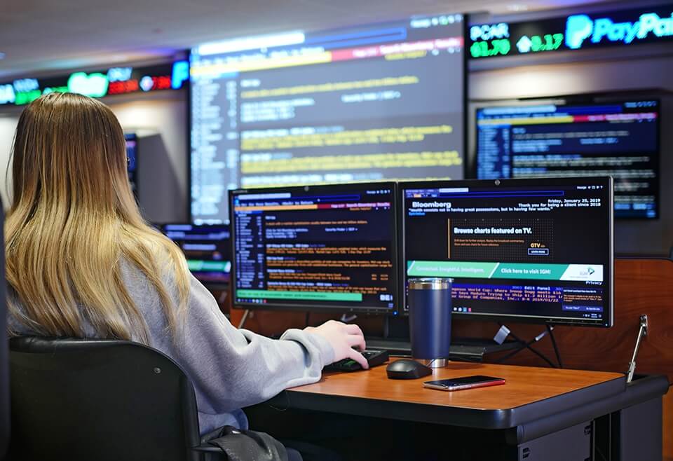 High school student using financial software in Nichols College's Bloomberg Experiential Trading room.