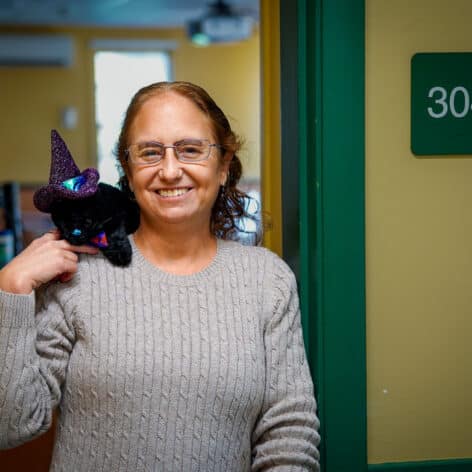 Professor Emily Thomas stands in doorway of Academy 304
