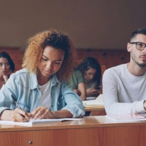 Student taking notes at desk