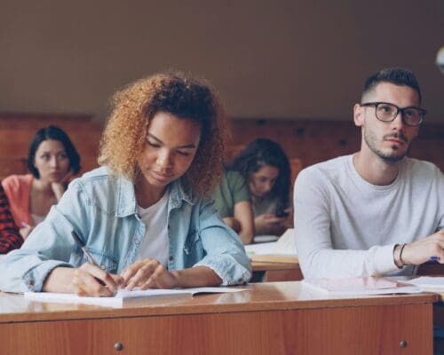 Student taking notes at desk
