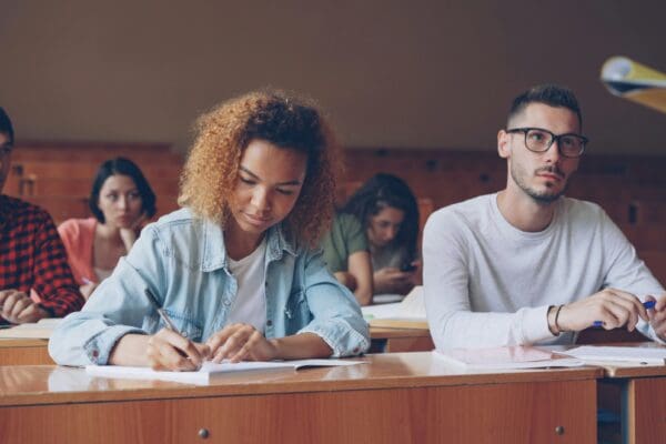Student taking notes at desk