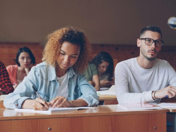 Student taking notes at desk