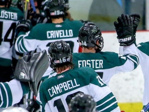 Nichols College Men's Hockey Captain high fiving his teammates