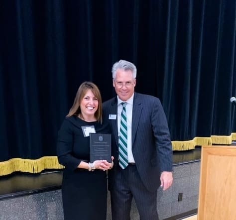 Newport Hospital President Crista Durand receives the Nichols College Alumni Achievement Award from Bill Pieczynski, vice president for advancement at Nichols, on October 15.