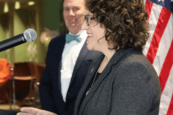 resident Glenn Sulmasy, JD, LL.M; Jean Beaupre, Ed.D., foreground, speaking at on-campus press conference on the college’s AACSB accreditation