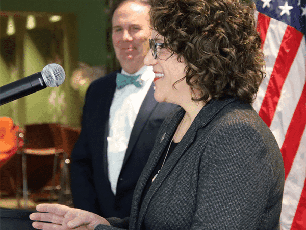 resident Glenn Sulmasy, JD, LL.M; Jean Beaupre, Ed.D., foreground, speaking at on-campus press conference on the college’s AACSB accreditation
