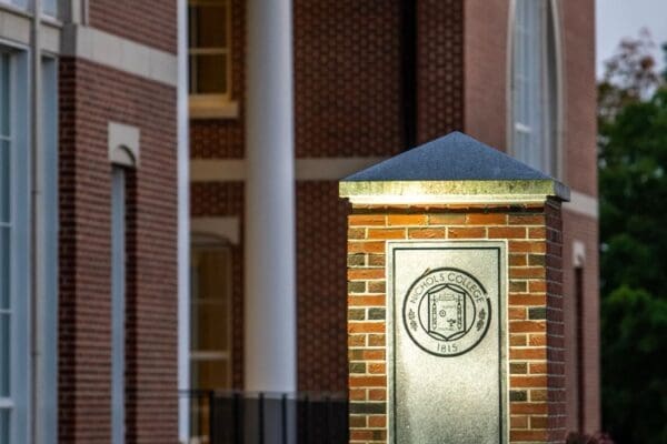 Nichols College emblem on a brick pillar