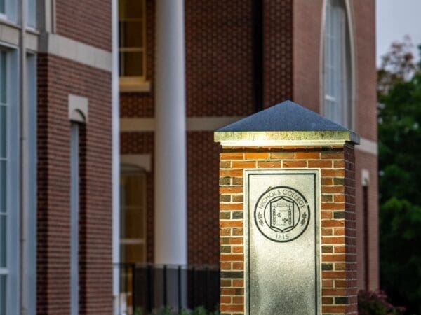 Nichols College emblem on a brick pillar