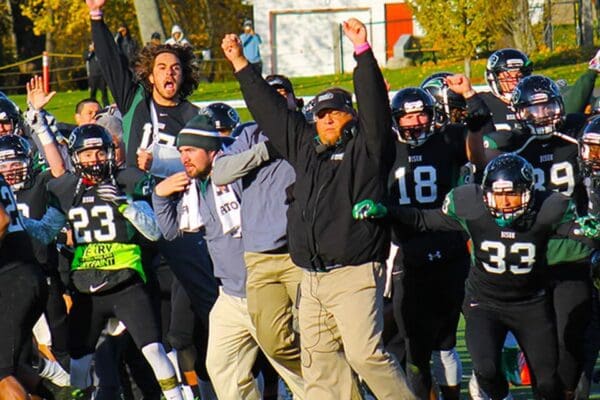 Football team celebrating in gave vs MIT