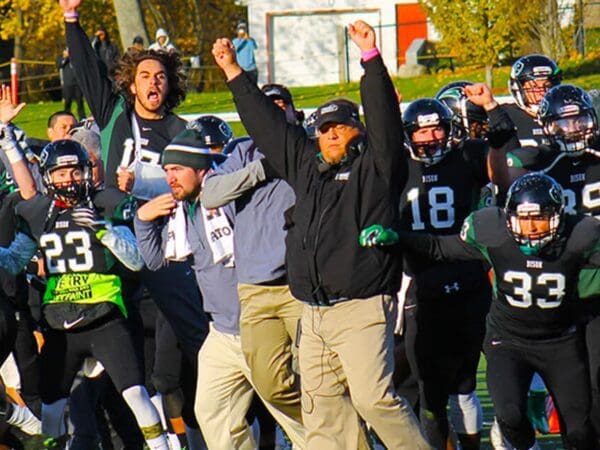 Football team celebrating in gave vs MIT