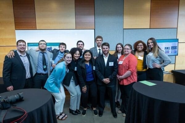 Student presenters pose for a photo in the New Academic Building during the REAL Symposium