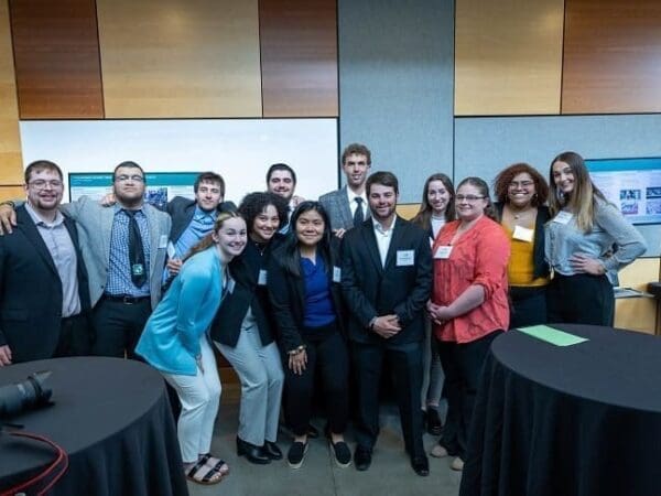 Student presenters pose for a photo in the New Academic Building during the REAL Symposium