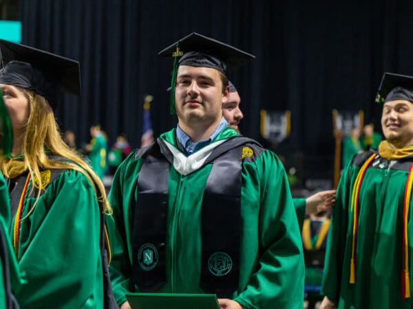 A Nichols College student holds his diploma at commencement in a procession line