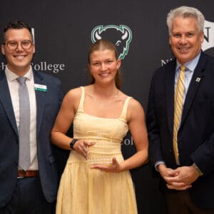 A student poses with the Dean of Students and the President at the annual Student Life Awards celebration.